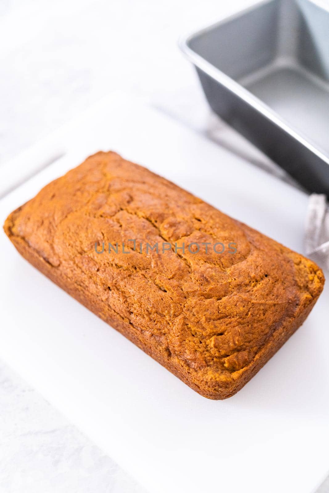 Sliced homemade pumpkin bread on a white cutting board.