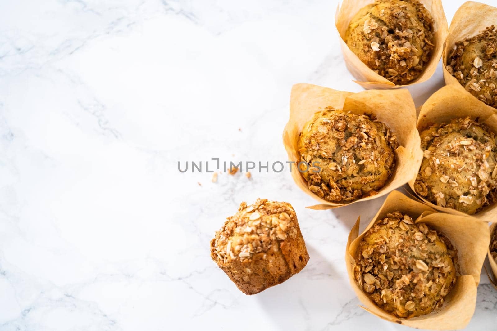 Freshly baked banana oatmeal muffins with oatmeal sugar topping.