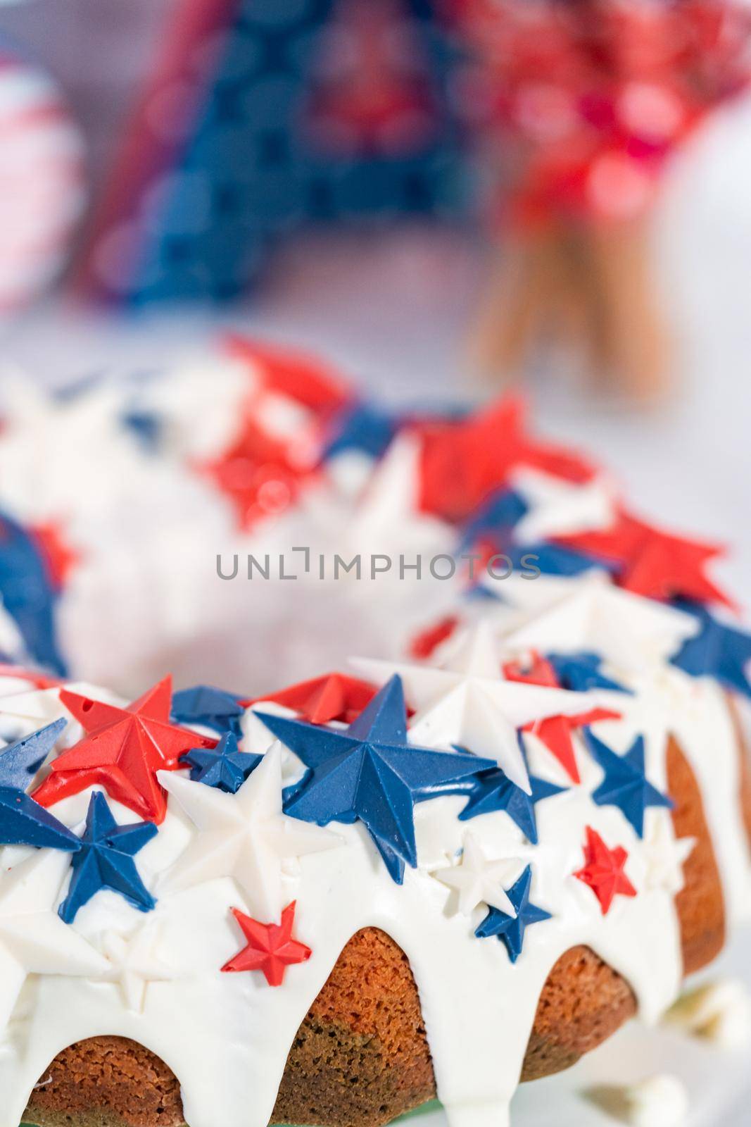 July 4th bundt cake covered with a vanilla glaze and decorated with chocolate stars on a white plate.