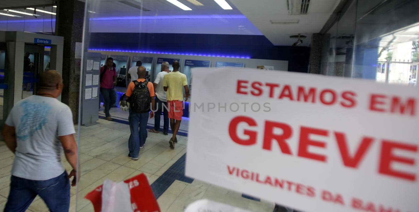 salvador, bahia / brazil - june 1, 2017: Poster stuck on door of Caixa Ecomica Agency warns of serious security guards on site.
