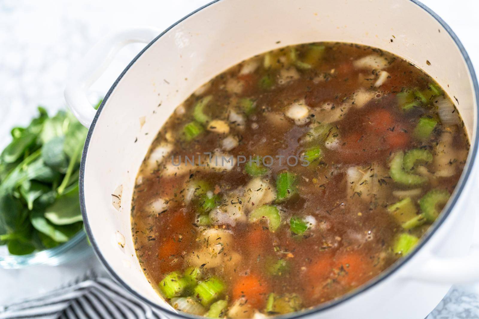 Cooking vegetarian white bean soup in cast iron dutch oven.