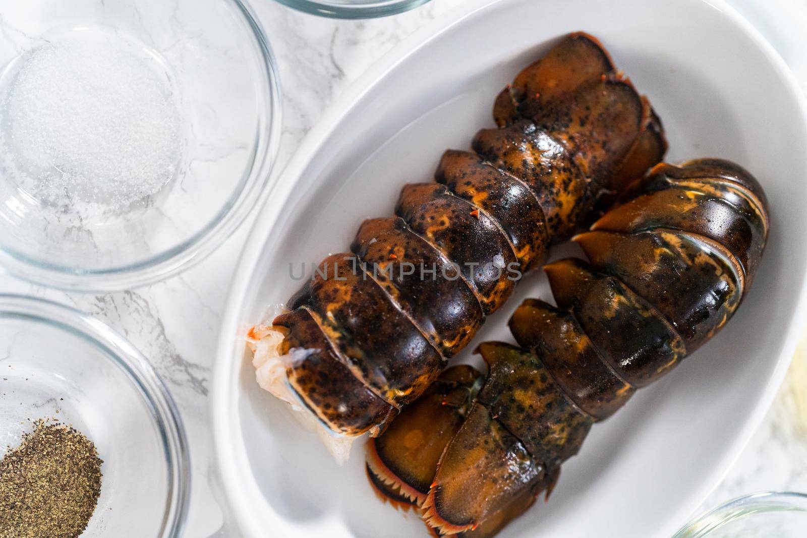 Flat lay. Measured ingredients in glass mixing bowls to prepare garlic lobster tails.