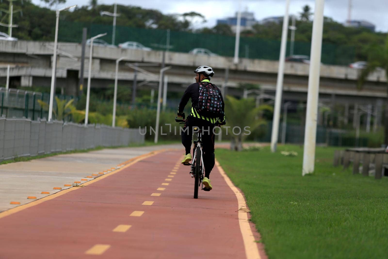 salvador, bahia, brazil - april 2, 2019: Person riding a bicycle on a bike path on Avenida Luiz Viana, along line 2 of the subway in the city of Salvador.