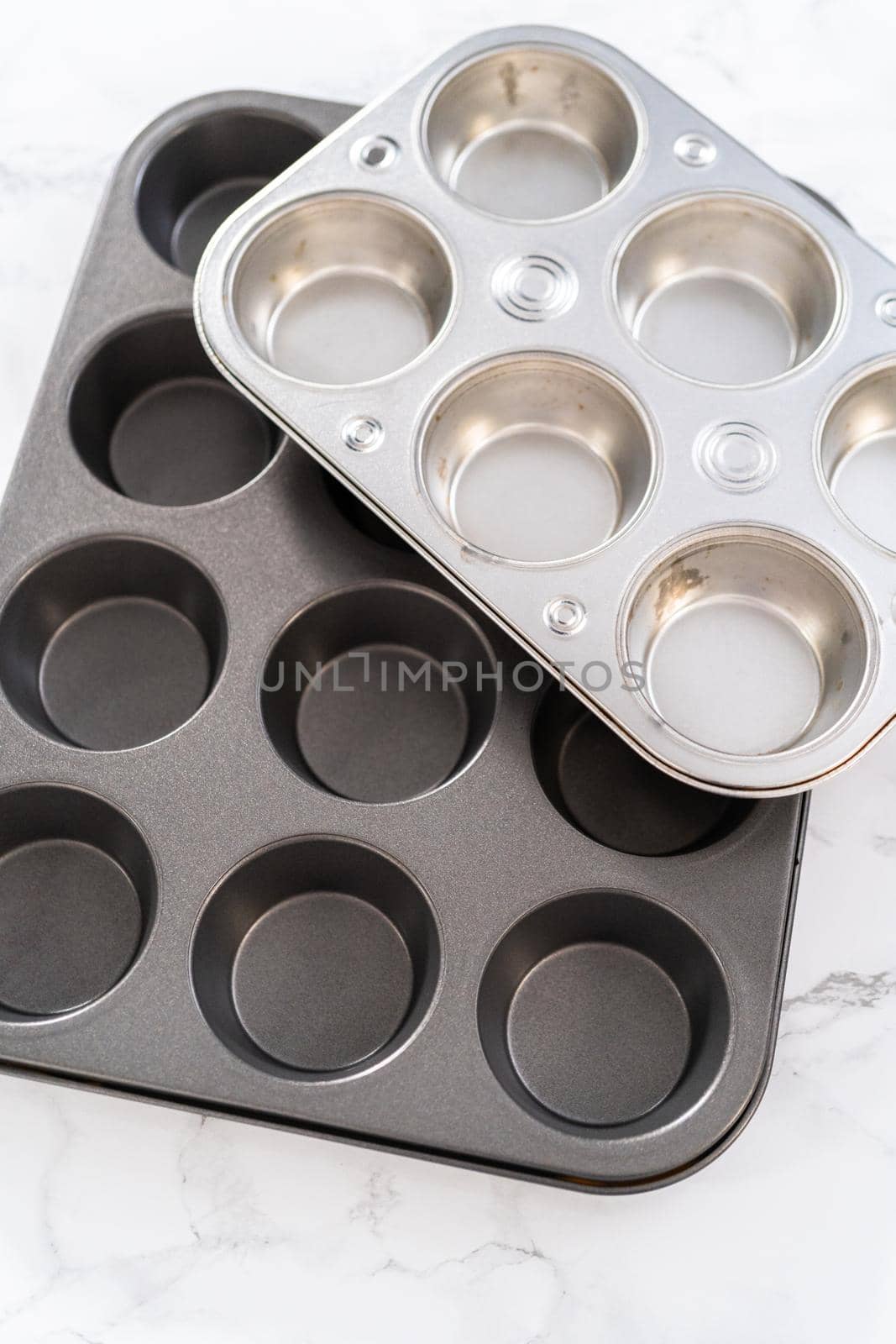 Close-up view. Metal baking pans for cupcakes on a marble countertop.