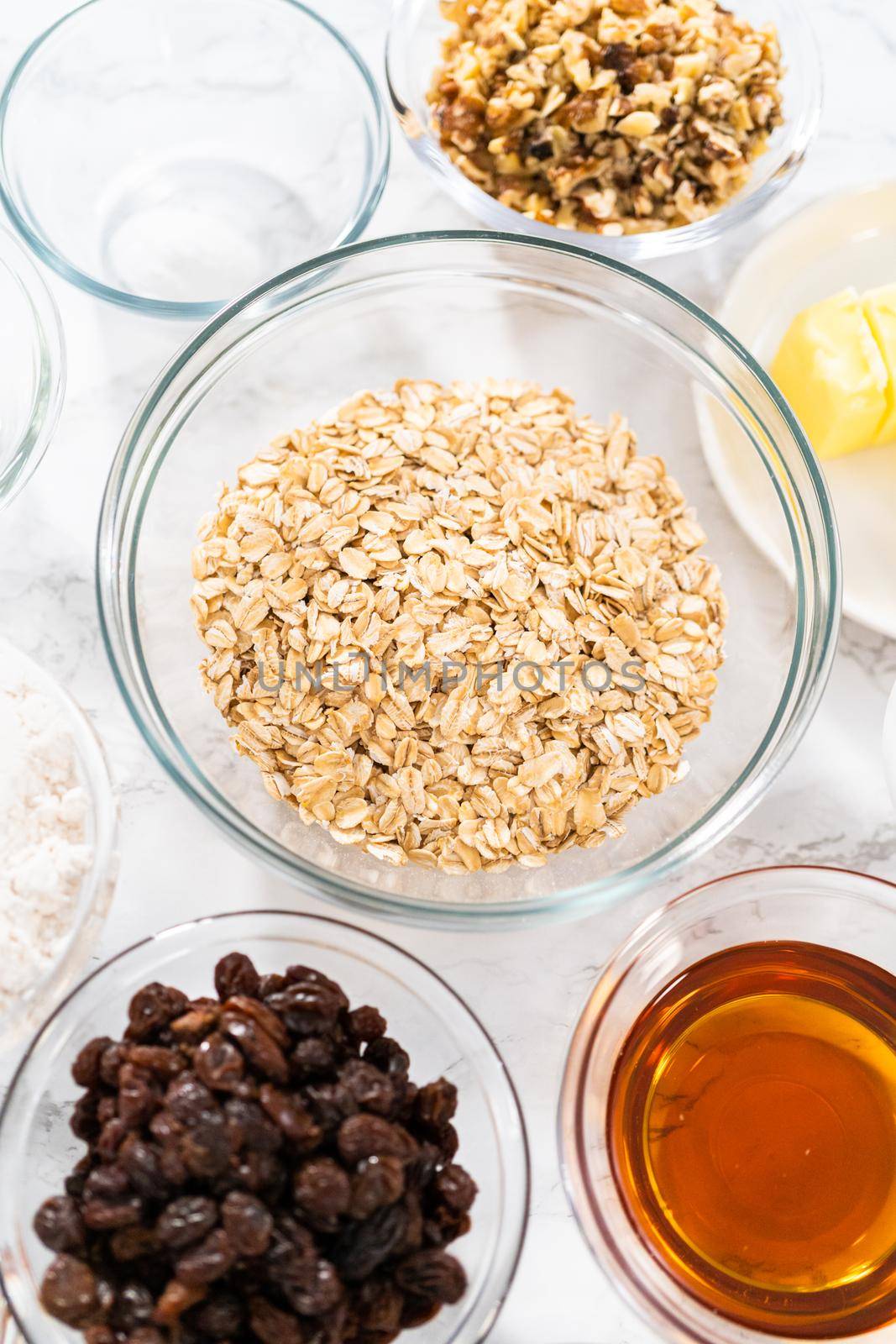 Measured ingredients in glass mixing bowls to bake soft oatmeal raisin walnut cookies.