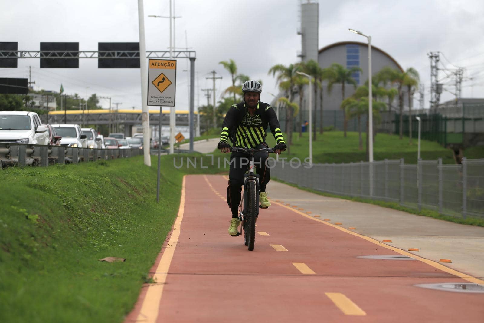 salvador, bahia, brazil - april 2, 2019: Person riding a bicycle on a bike path on Avenida Luiz Viana, along line 2 of the subway in the city of Salvador.