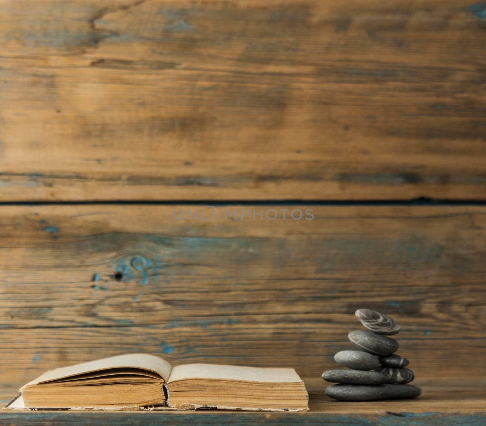 books and stack of zen stones on wood table background. Feng Shui, Balance and relaxation concept. 