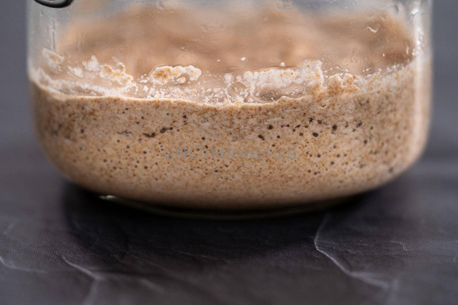 Homemade wheat sourdough starter in a glass mason jar.