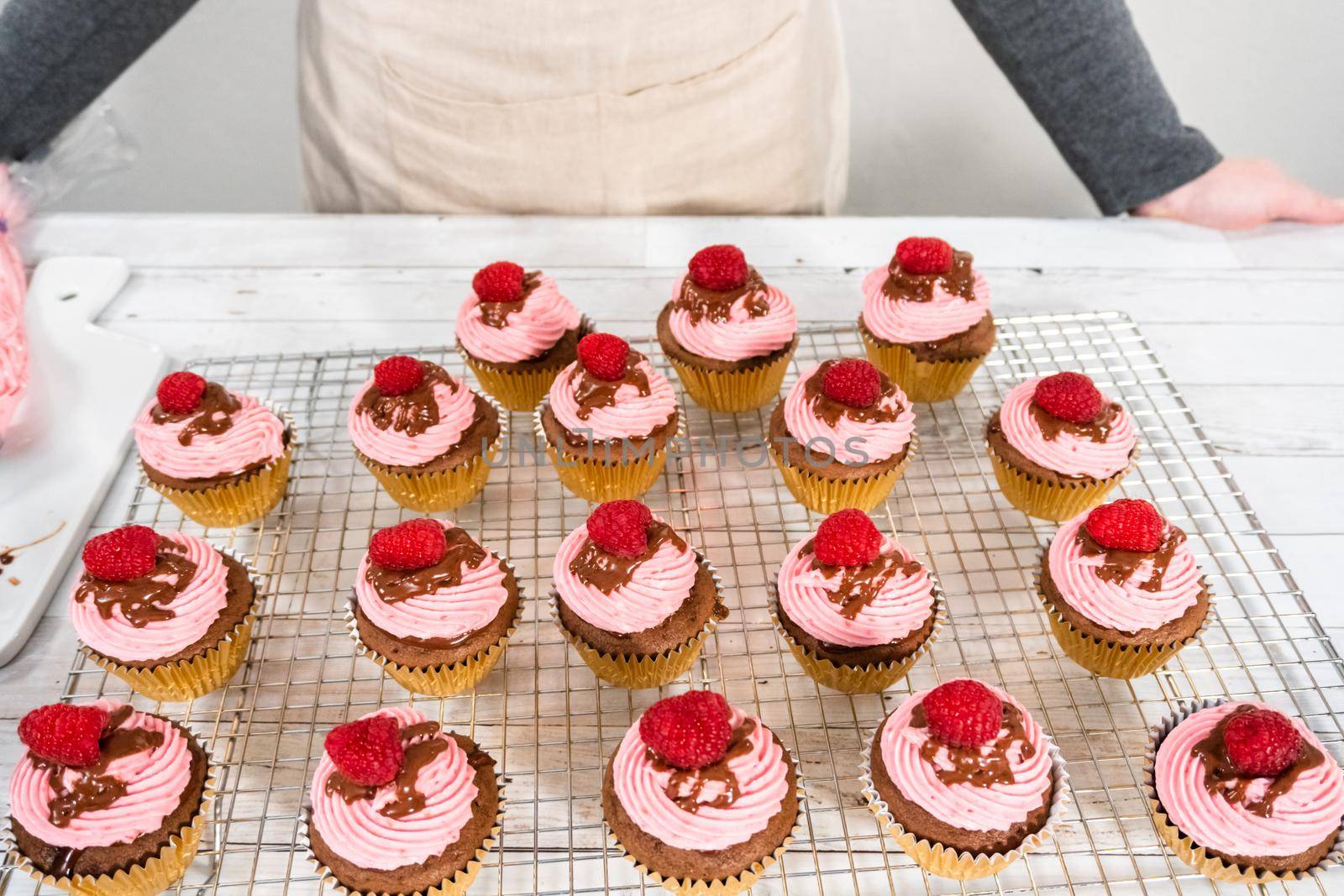 Gourmet chocolate raspberry cupcakes drizzled with chocolate ganache and topped with a fresh raspberry.
