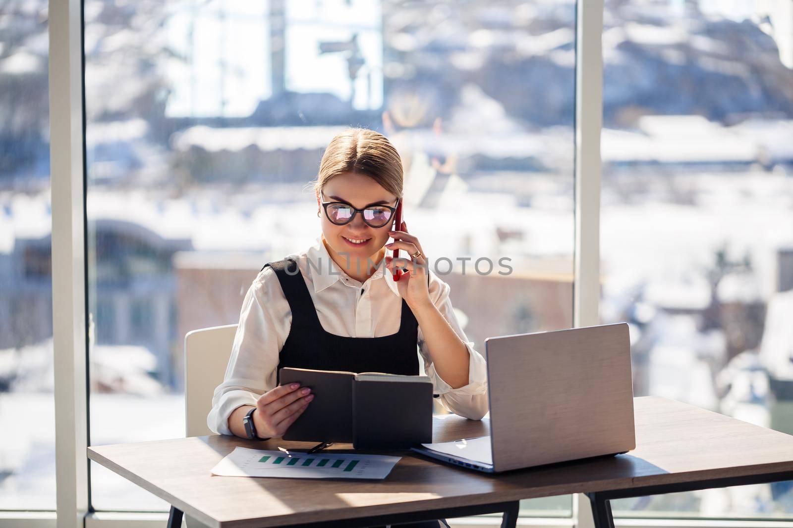 Successful woman mentor, director, businessman in glasses and a suit is studying documents, sitting at the table. Working day concept