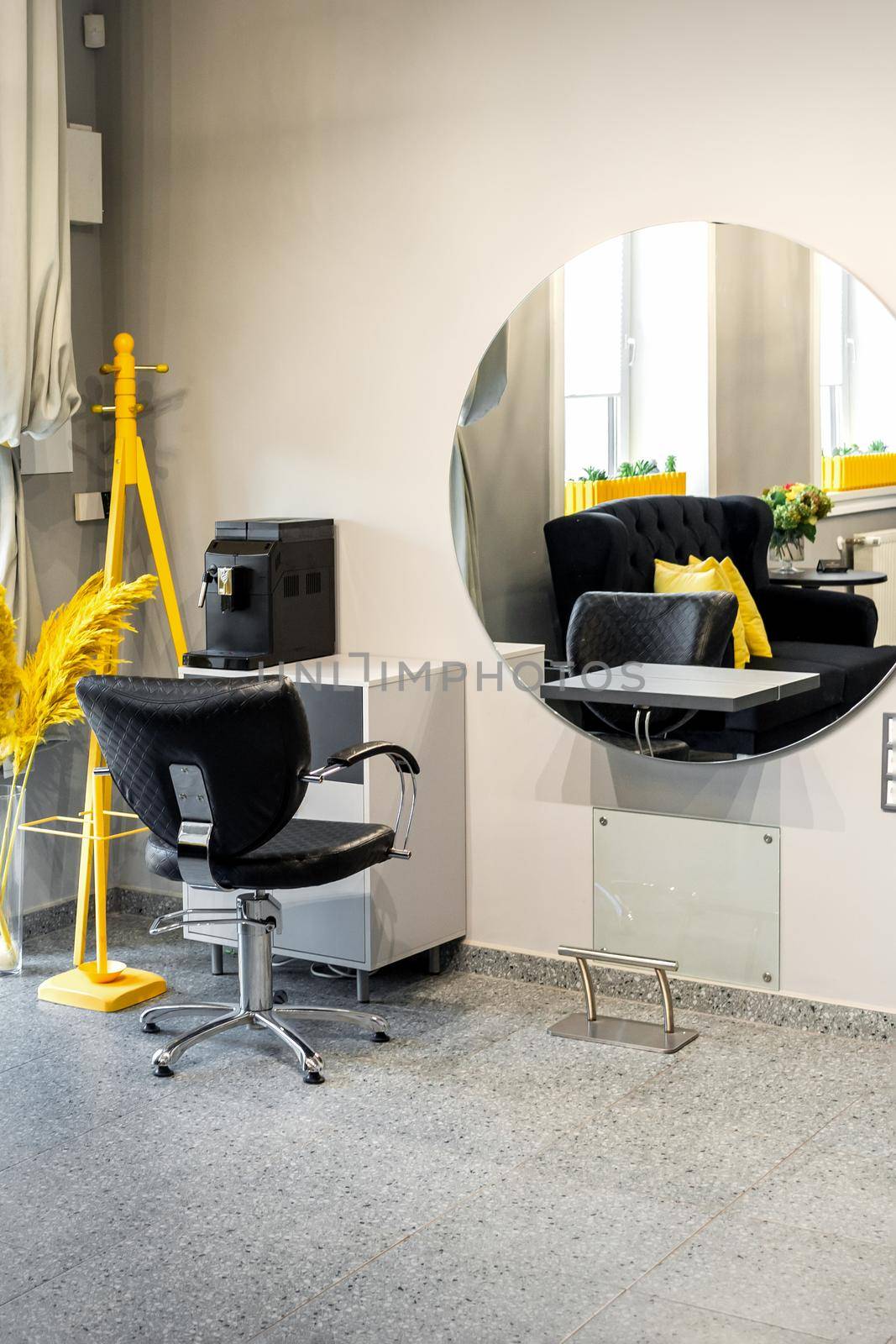 Modern small bright hair and beauty salon in black and yellow colors with gray walls and floor