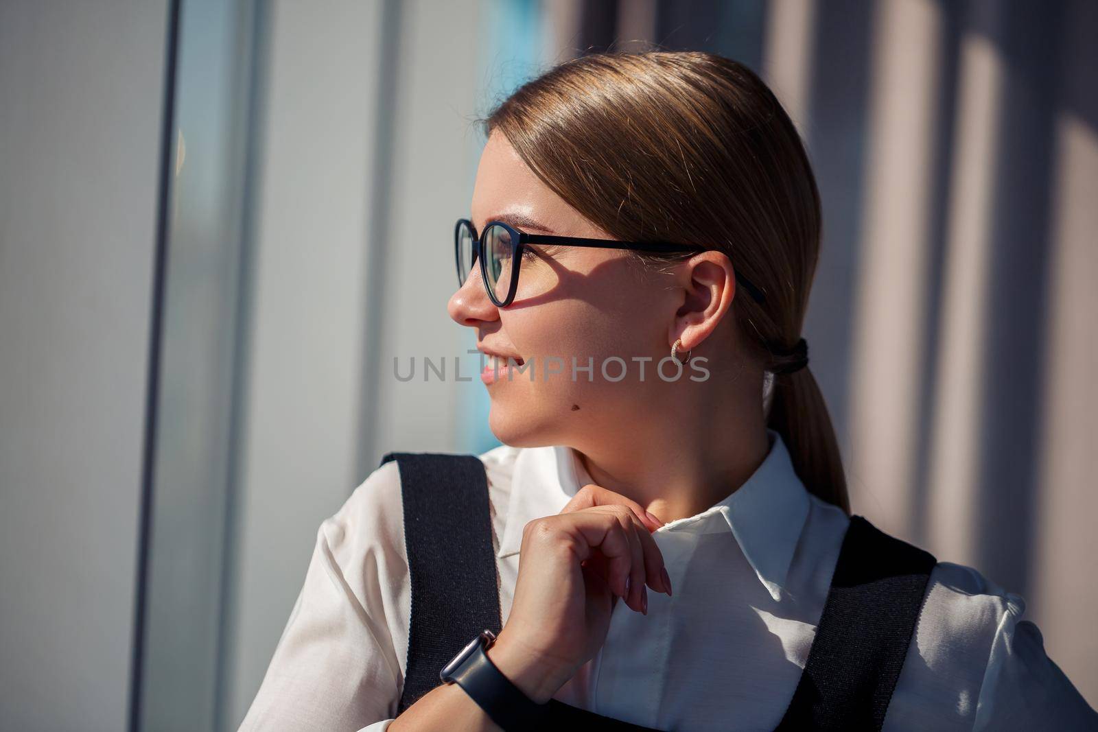 Confident business woman boss standing in modern office wearing glasses, female leader, business owner thinking about future success, planning new opportunities