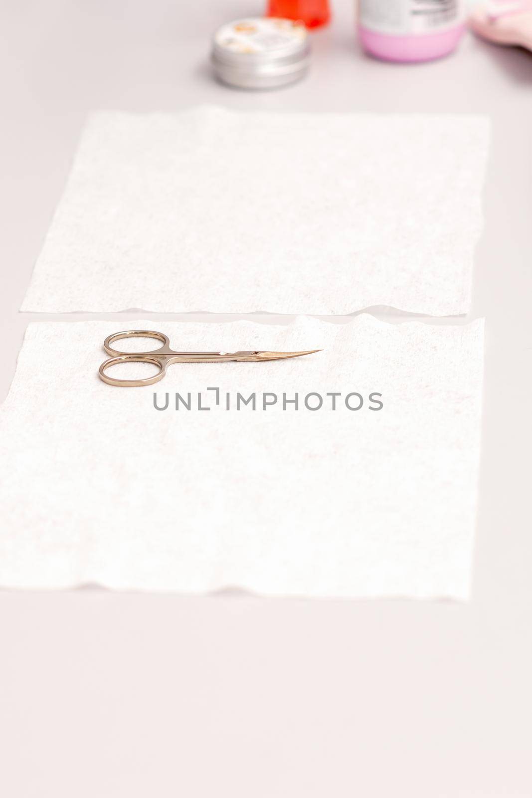 Hands of manicure master prepare nail care tools on a white table