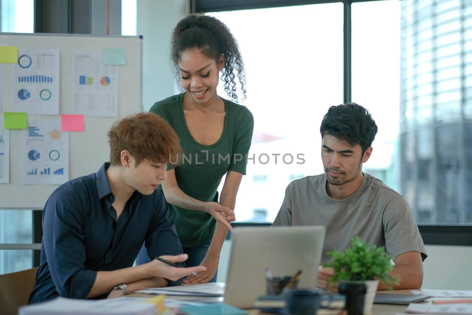 Group of young asian business people in smart casual wear working together in creative office using laptop..