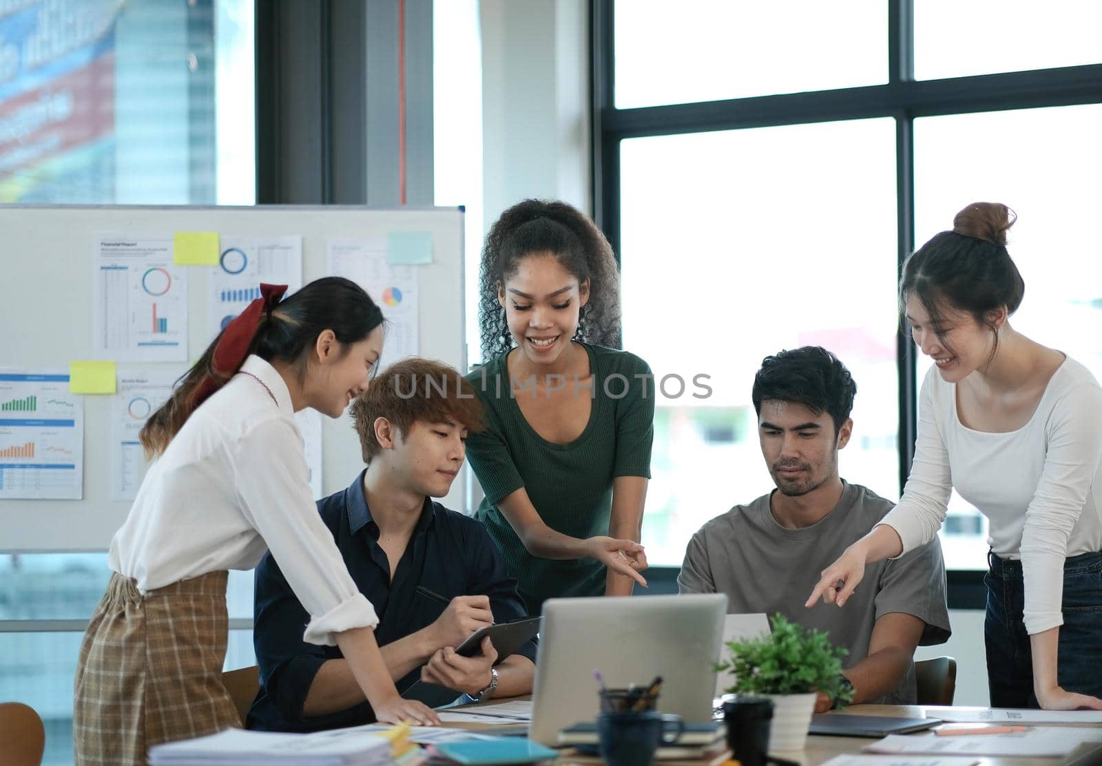 Group of young asian business people in smart casual wear working together in creative office using laptop..