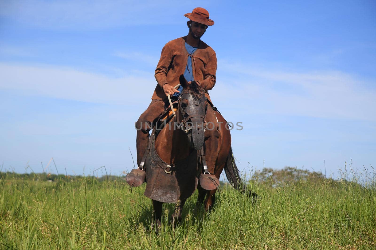 conde, bahia, brasil - january 8, 2022: Cowboy wearing traditional leather clothes with his horse on a farm in the city of Conde.
