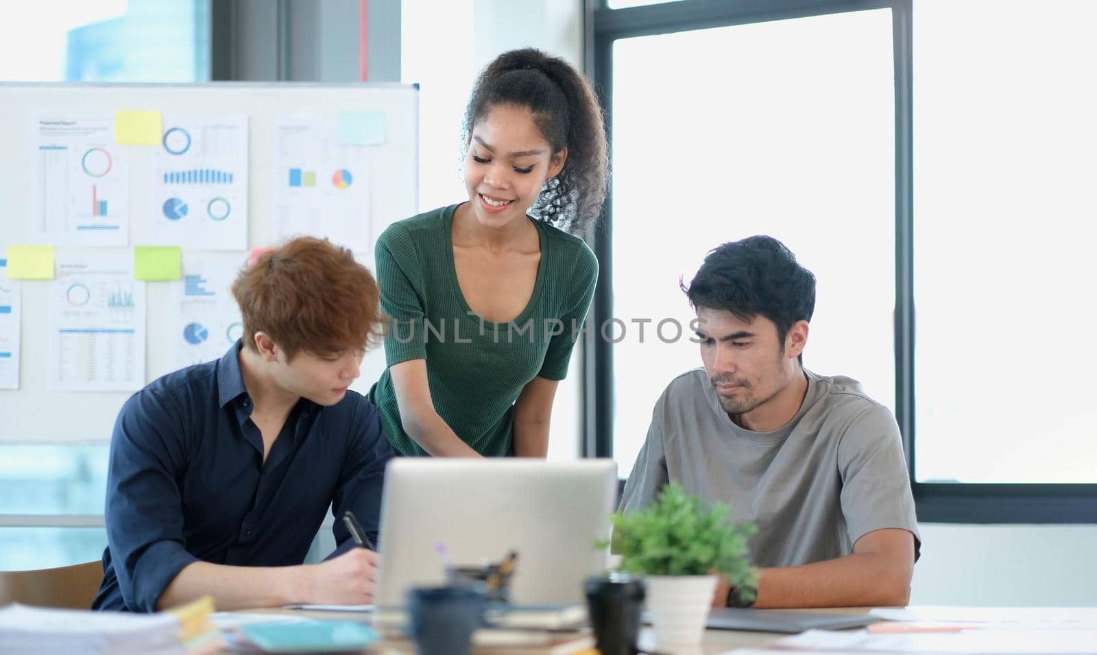 Group of young asian business people in smart casual wear working together in creative office using laptop..