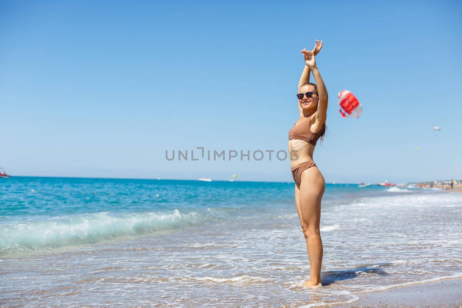 Young woman with blond hair posing and resting on the ocean. A beautiful athletic body of a tourist on the island. Selective focus.