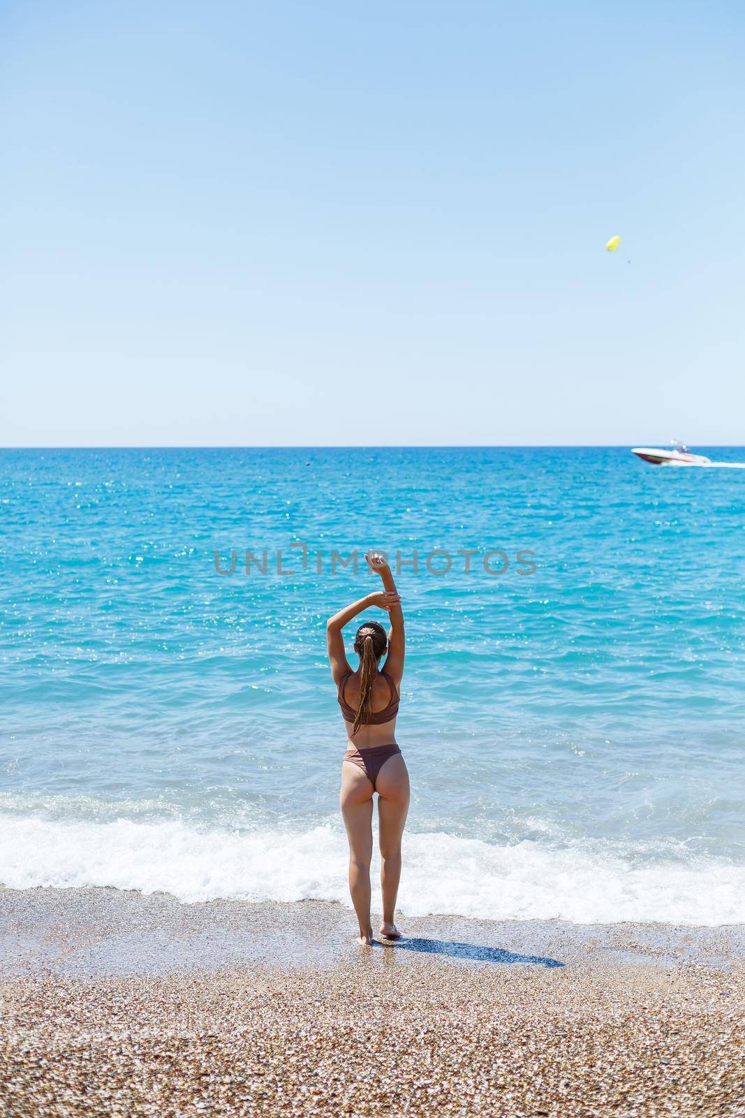Young woman with blond hair posing and resting on the ocean. A beautiful athletic body of a tourist on the island. Selective focus.