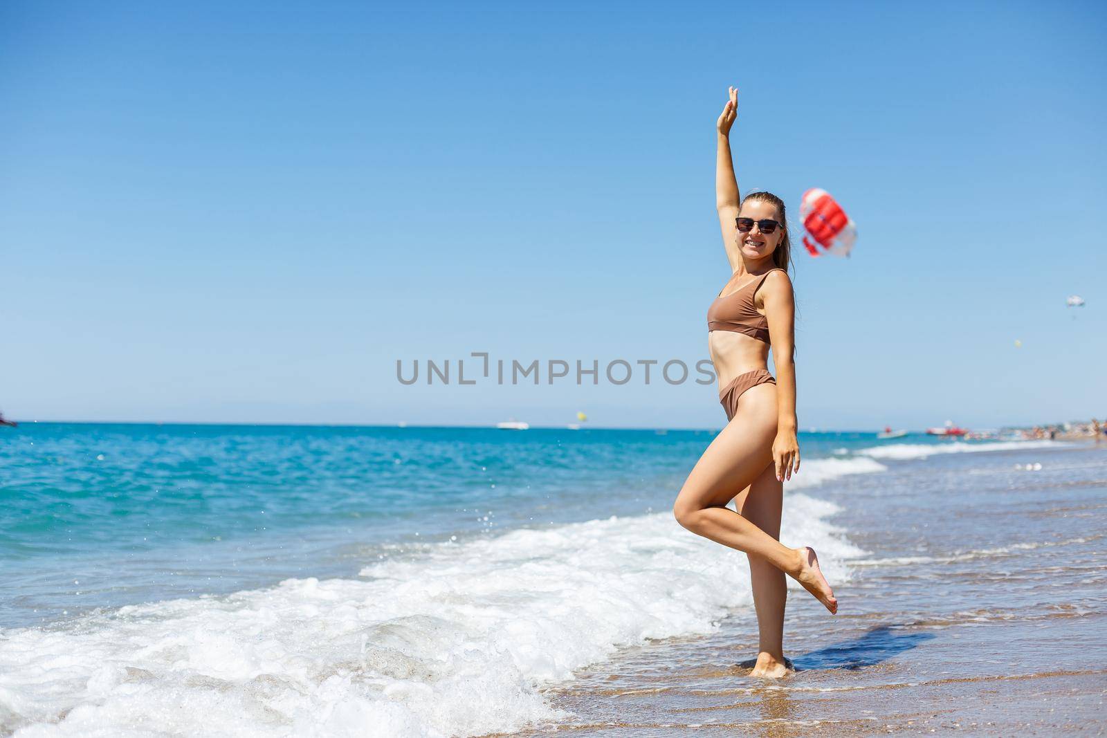 Young woman with blond hair posing and resting on the ocean. A beautiful athletic body of a tourist on the island. Selective focus.