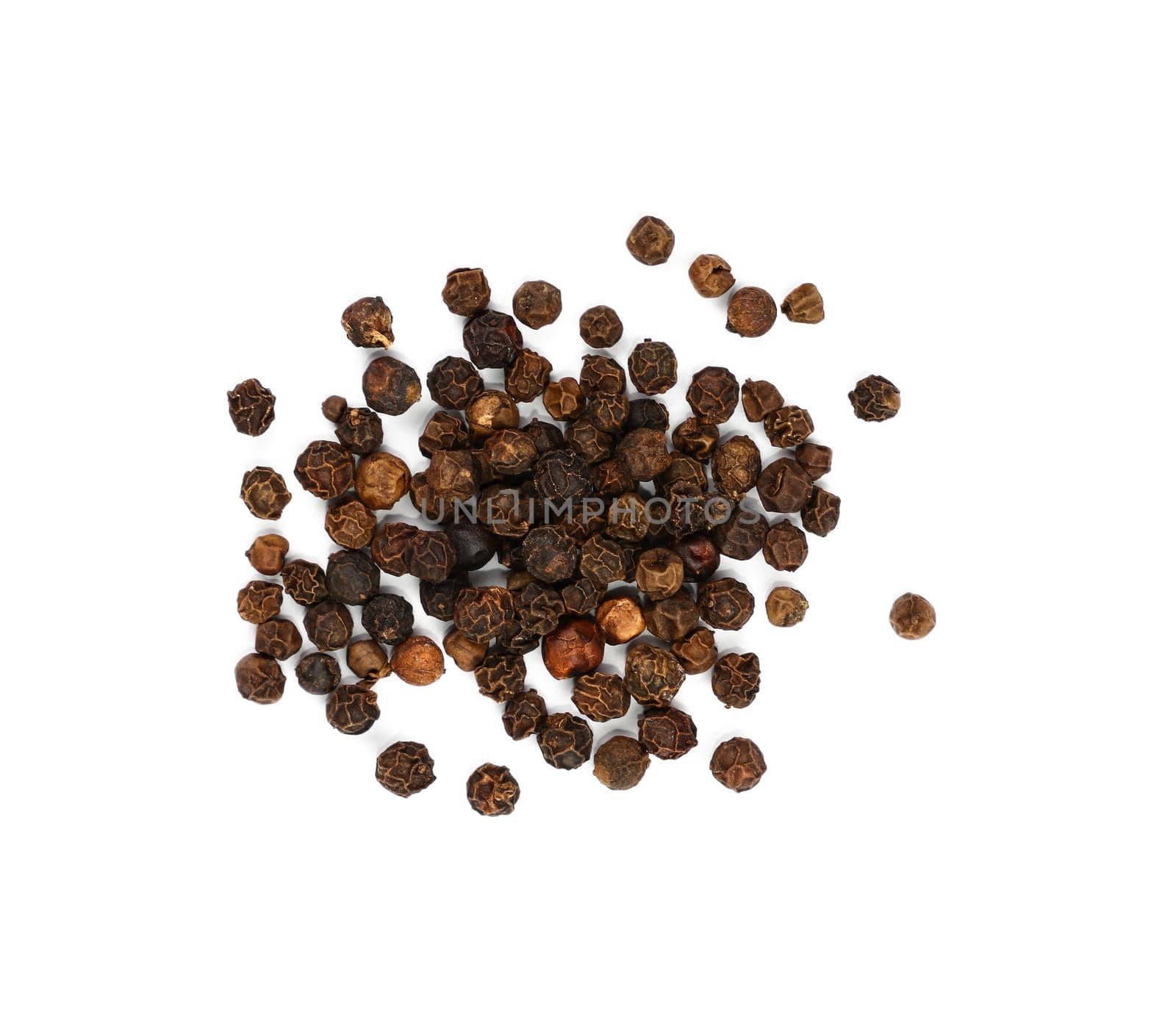 Close up heap of black pepper peppercorns spilled and spread around isolated on white background, elevated top view, directly above