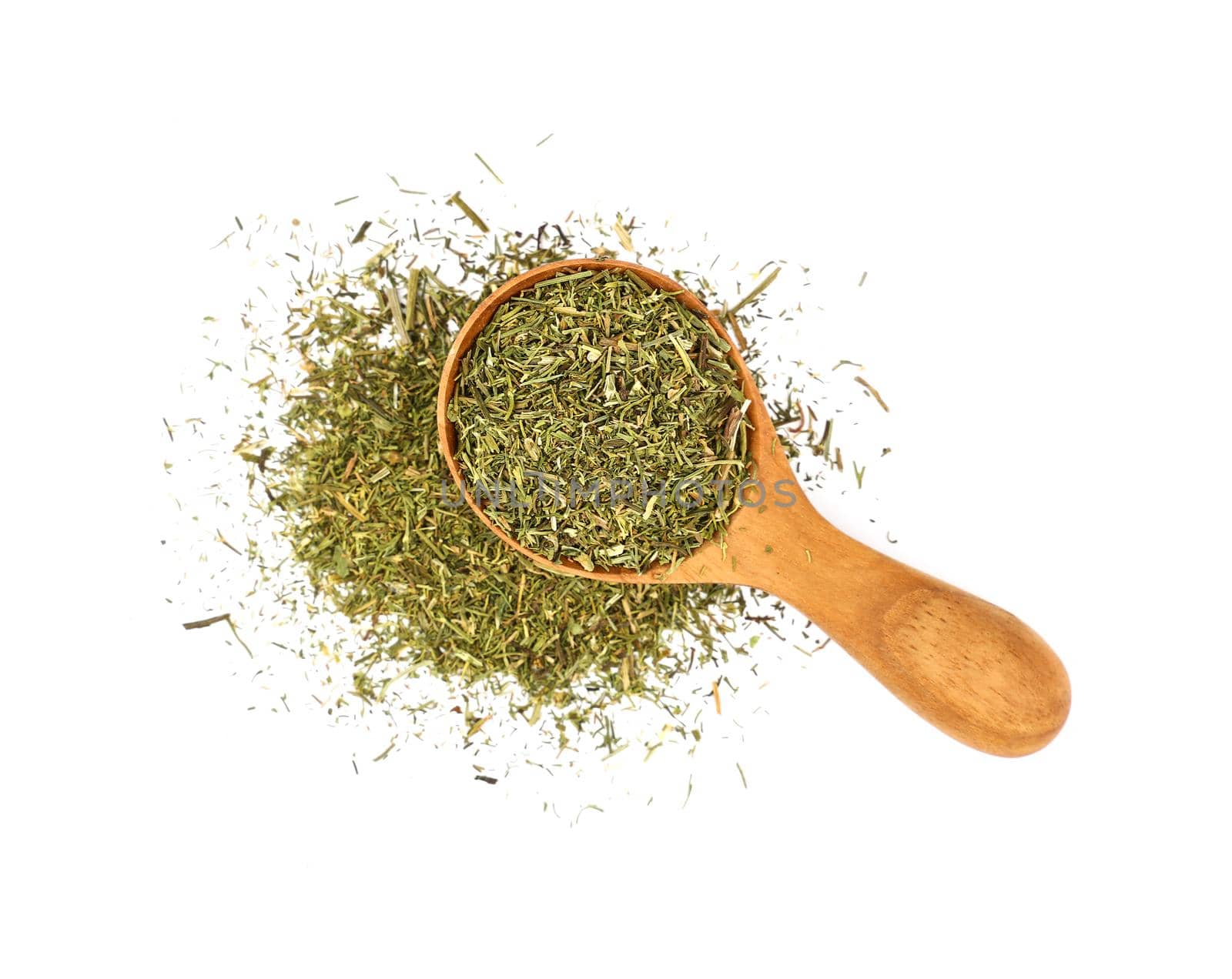 Close up one wooden scoop spoon full of green dried herbs spilled and spread around, dill or marjoram isolated on white background, elevated top view, directly above