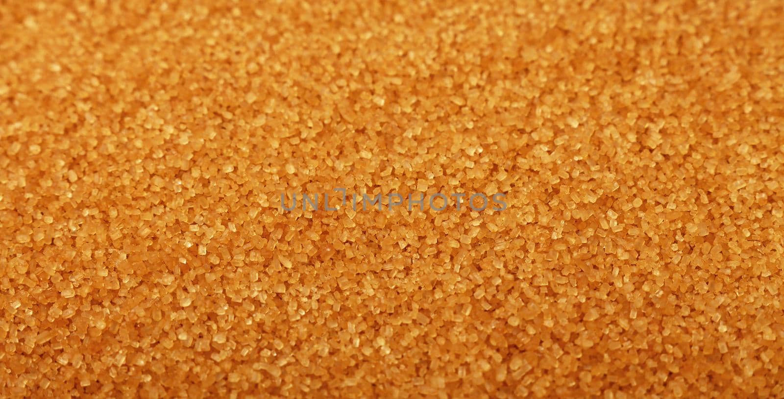 Close up background texture of brown raw cane sugar, high angle view