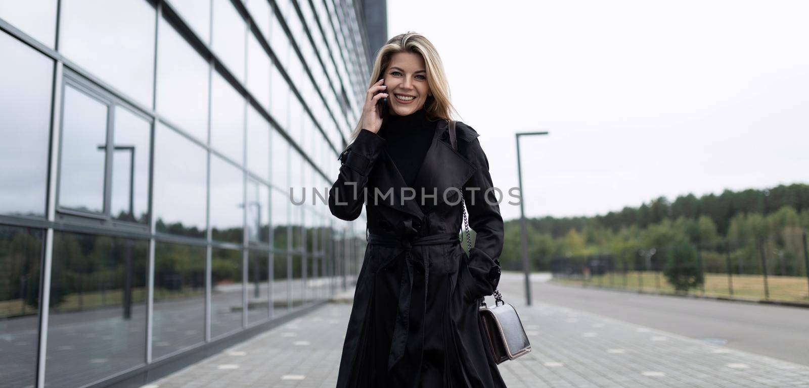 woman businesswoman rushing about business talking on mobile phone with a smile on her face.