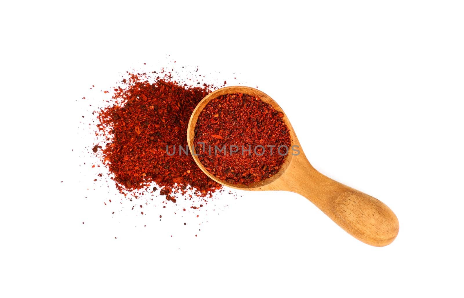 Close up one wooden scoop spoon full of ground sundried tomatoes, heap of powder spilled around, isolated on white background, elevated top view, directly above
