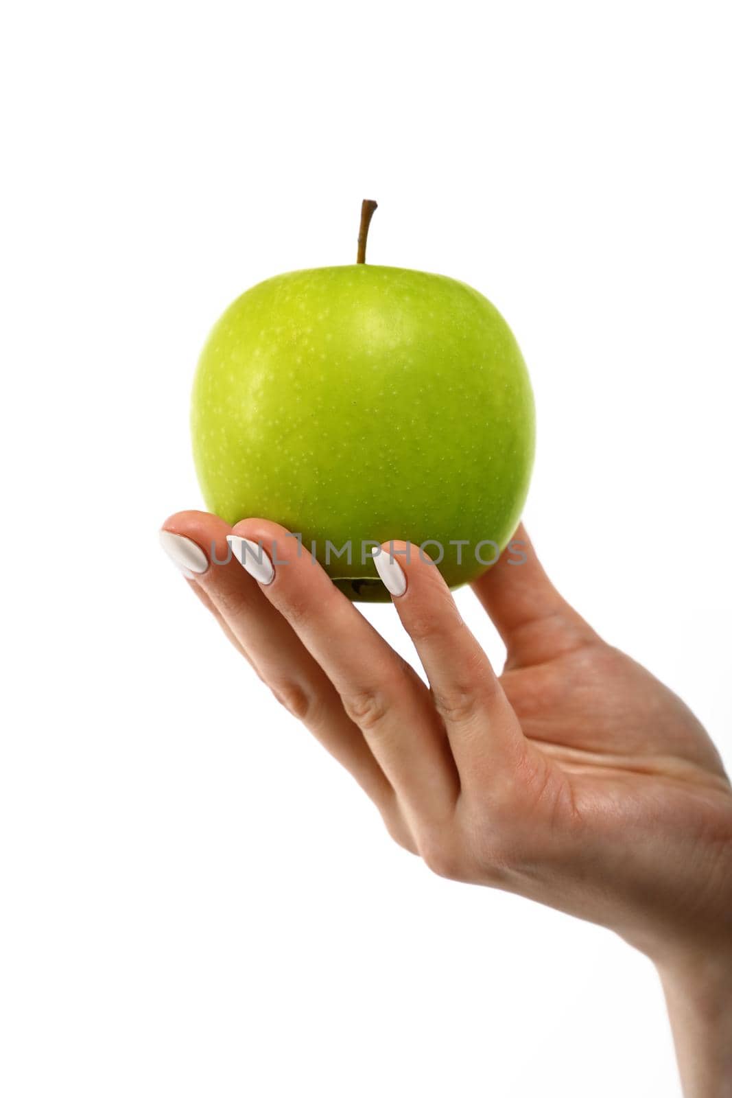 Close up Caucasian woman hand holding one fresh green apple isolated on white background, symbol of healthy eating concept, low angle, side view