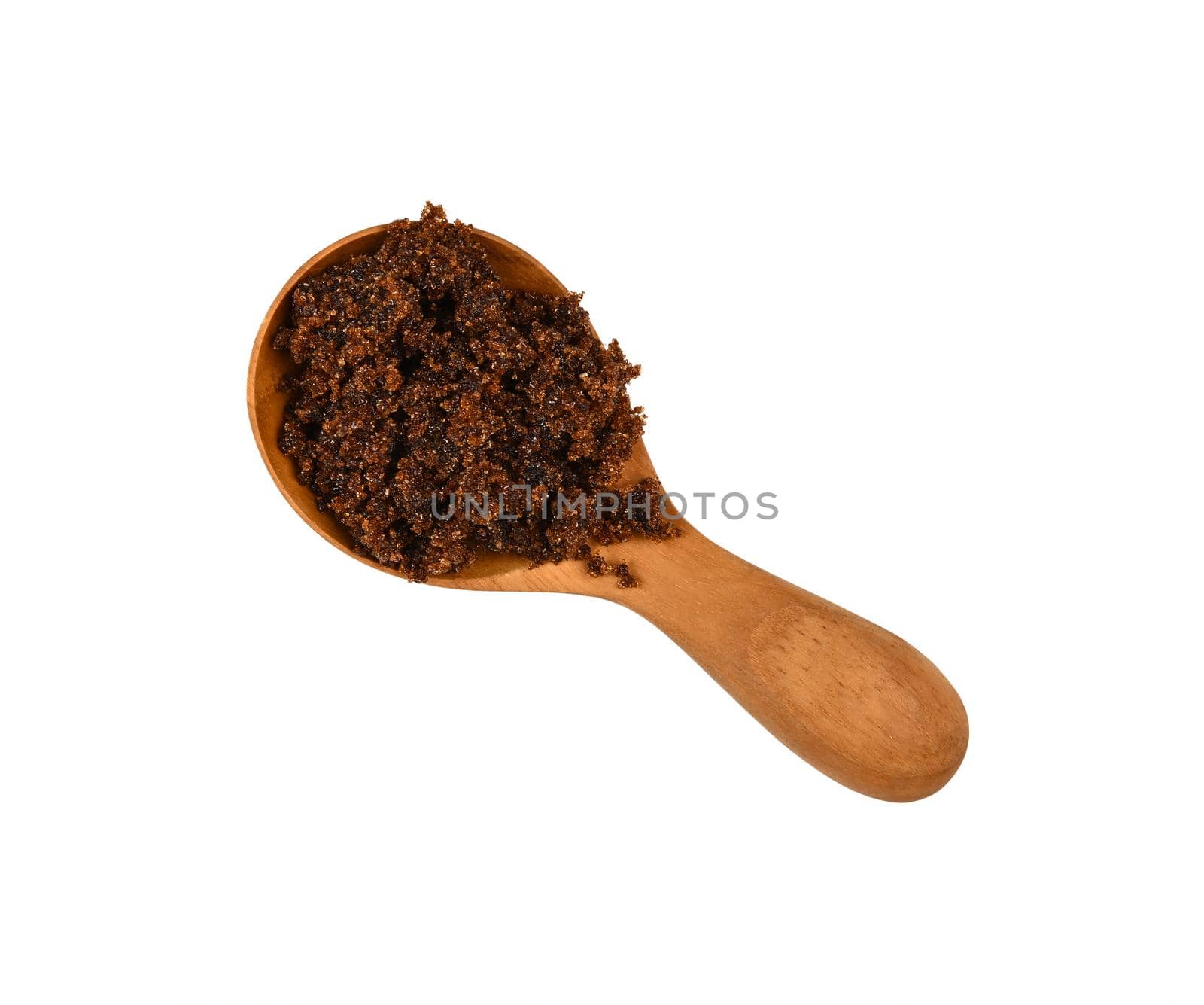 Close up one wooden scoop spoon of brown unrefined muscovado cane sugar isolated on white background, top view