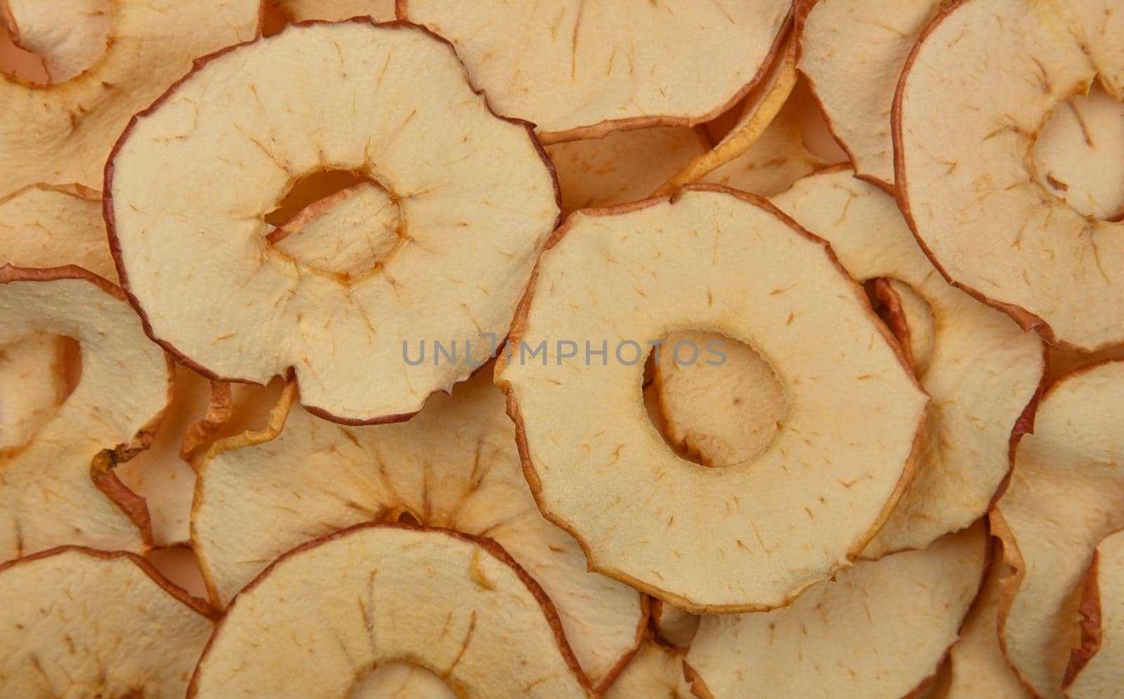 Close up many dried crispy apple ring chips on retail display, elevated top view, directly above