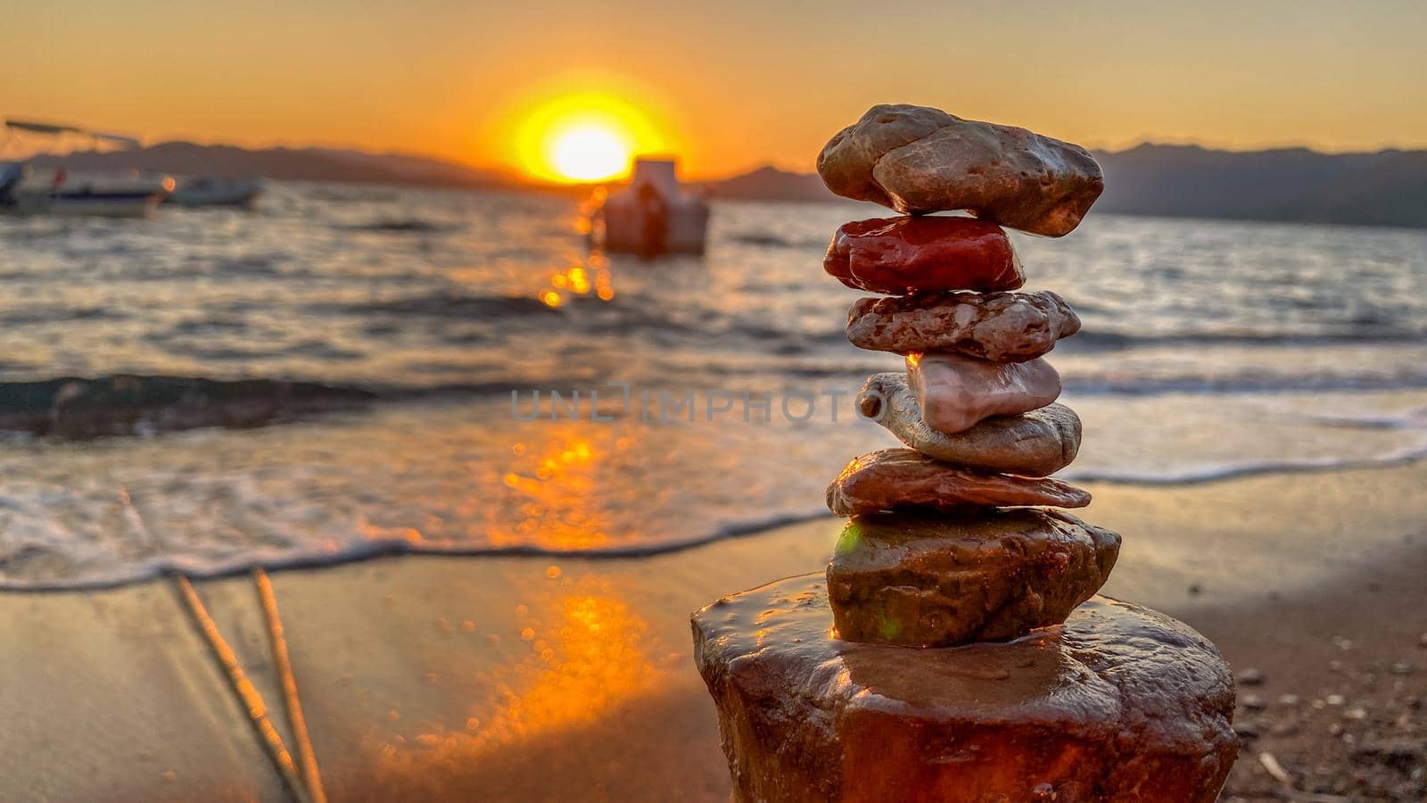 Rock balancing at the beach at sunset close up view