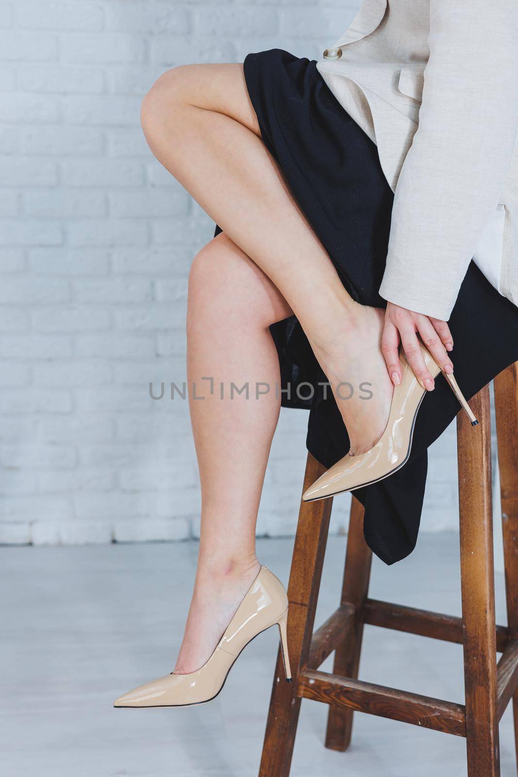 Close-up of female legs in beige stylish leather shoes with heels. Fashionable woman in new shoes. Modern seasonal collection of stylish shoes. Women's fashion.