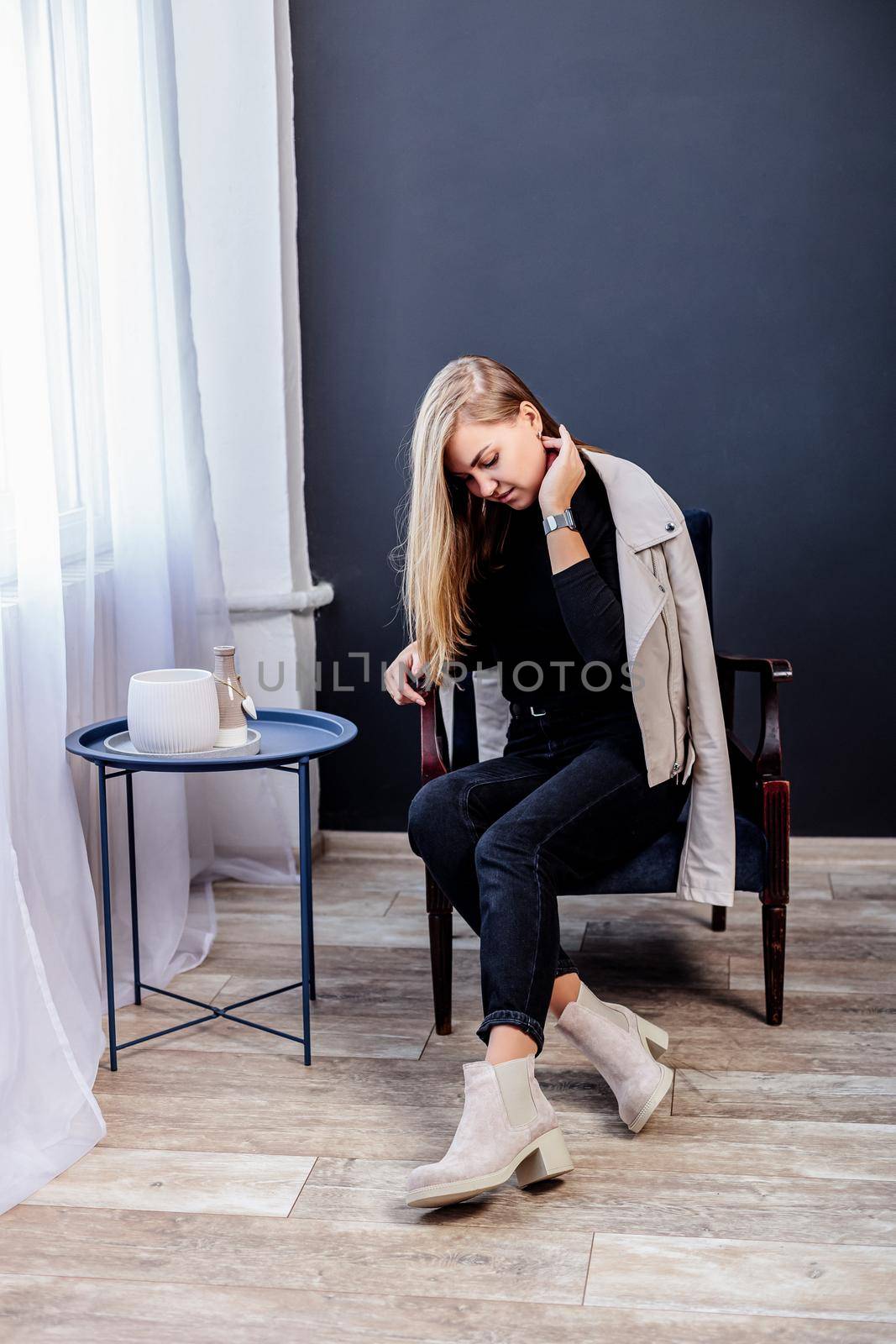 Pretty young woman in fashionable clothes with black jeans and fashionable shoes. Beautiful female legs in leather boots