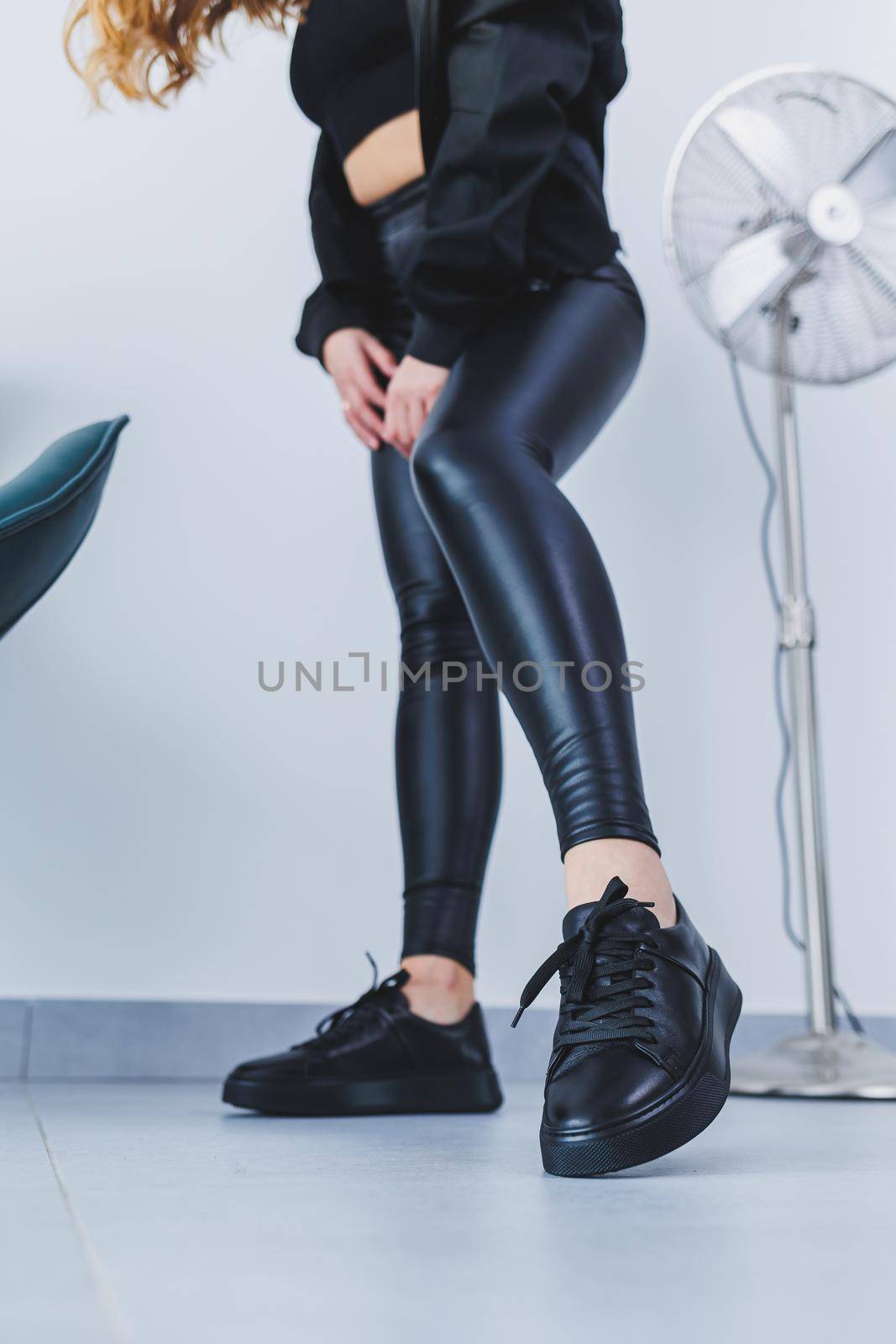 New collection of women's leather shoes, female legs close-up in black lace-up sneakers. Shoes for spring and summer by Dmitrytph