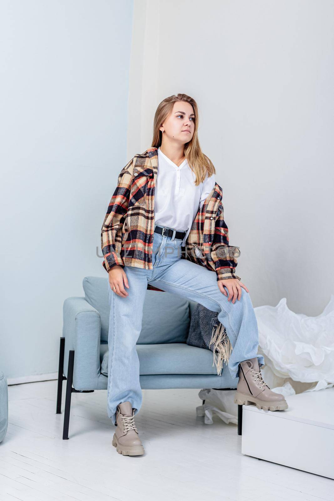 Stylish pretty young woman in fashionable clothes with blue jeans and fashionable shoes. Beautiful female legs in leather boots