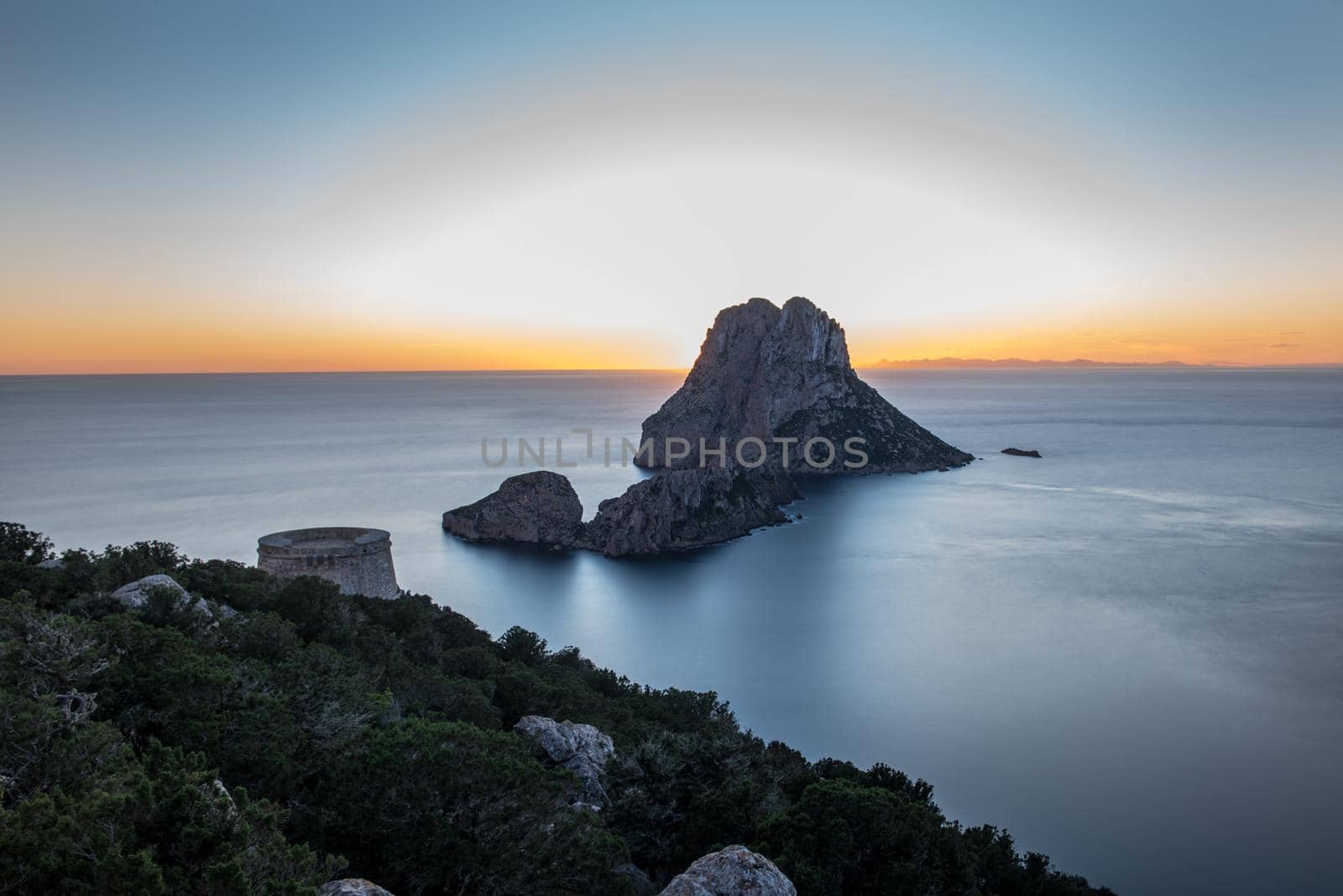 Stunning views of the sun falling behind Es Vedra with the Torre del Savinar in Es Vedra, Sant Josep de Sa Talaia, Ibiza, Spain by martinscphoto