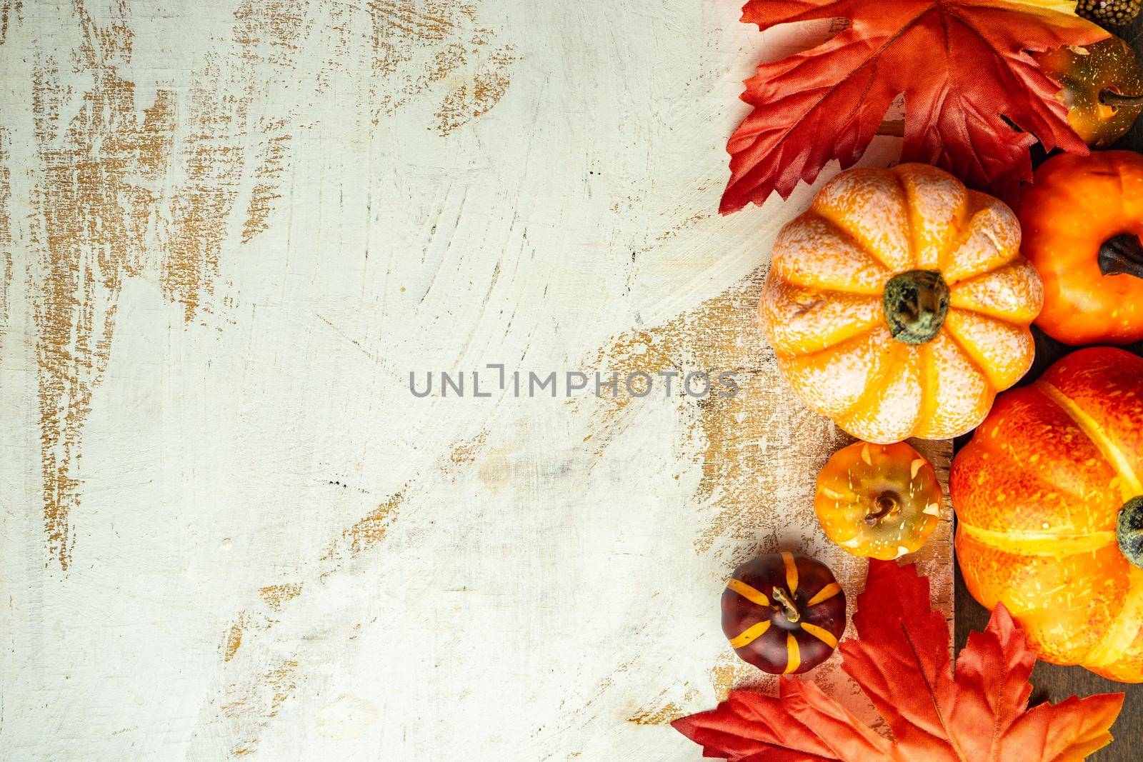 Autumnal flat lay with leaves and pumpkins on wooden background