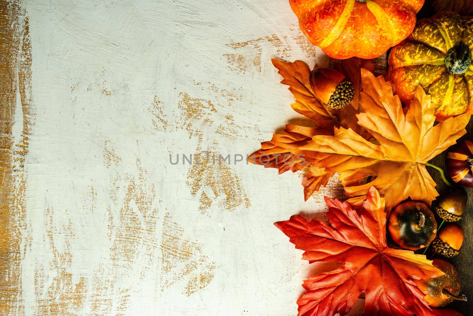 Autumnal flat lay with leaves and pumpkins on wooden background