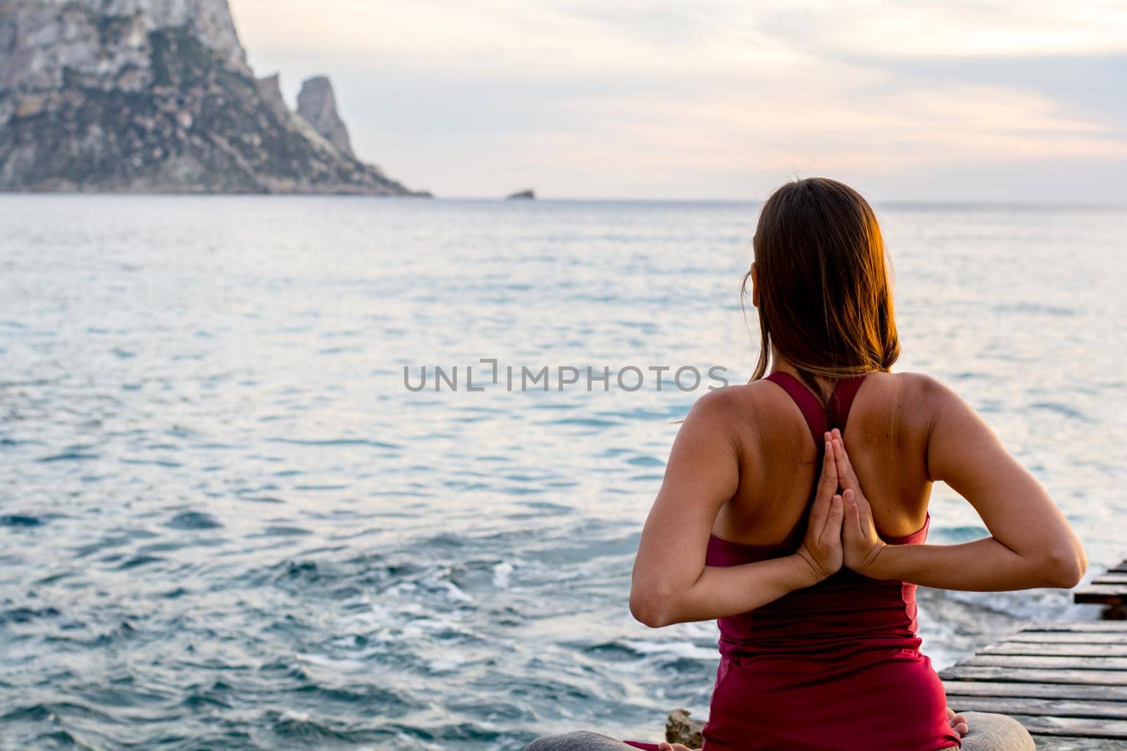 Es vedra, Ibiza : 2015 April 19 : Attractive woman practice yoga at beach with sunset or sunrise in Es Vedra, Ibiza, Spain.