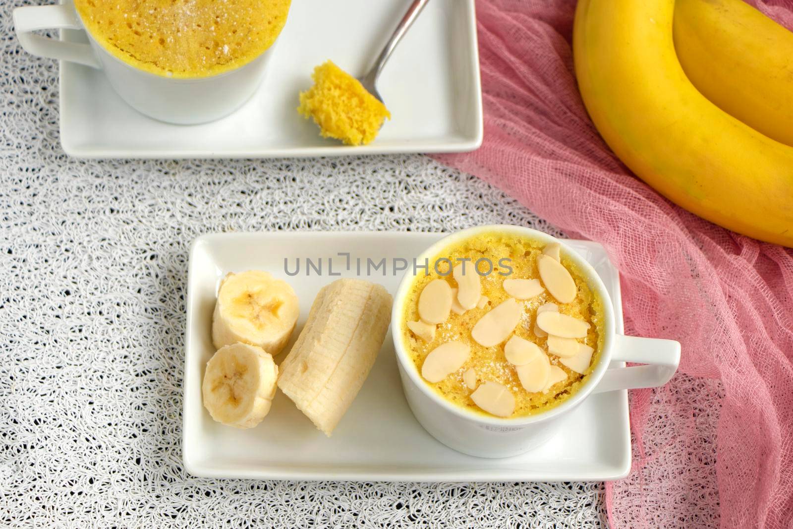 mini cake. Breakfast in a mug. selective focus. homemade Portioned Banana mugcake in small mugs. Easy sweet baking in the microwave idea, With fresh bananas, nuts. Muffin with banana slices cooked