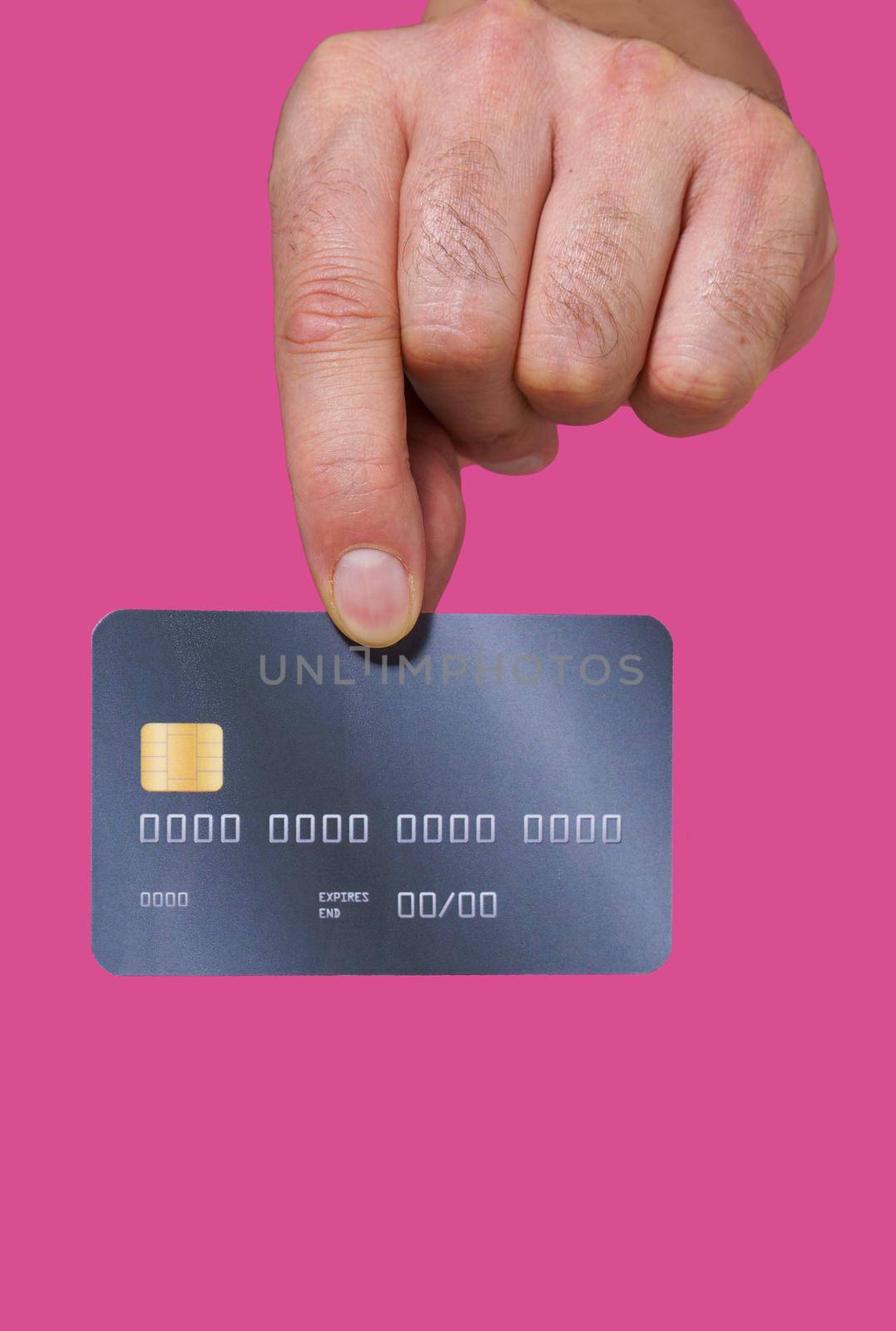 Close up, man hand holding credit, debit bank card with two fingers. Male hand with credit card. Plastic banking card in man hand isolated on pink background by LipikStockMedia