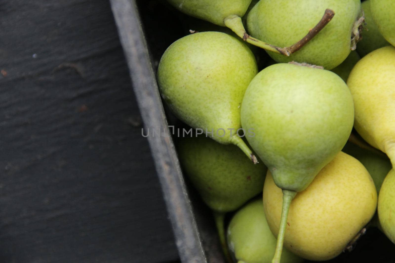 Ripe pears in a box on the table. Place for text. by Markgraf