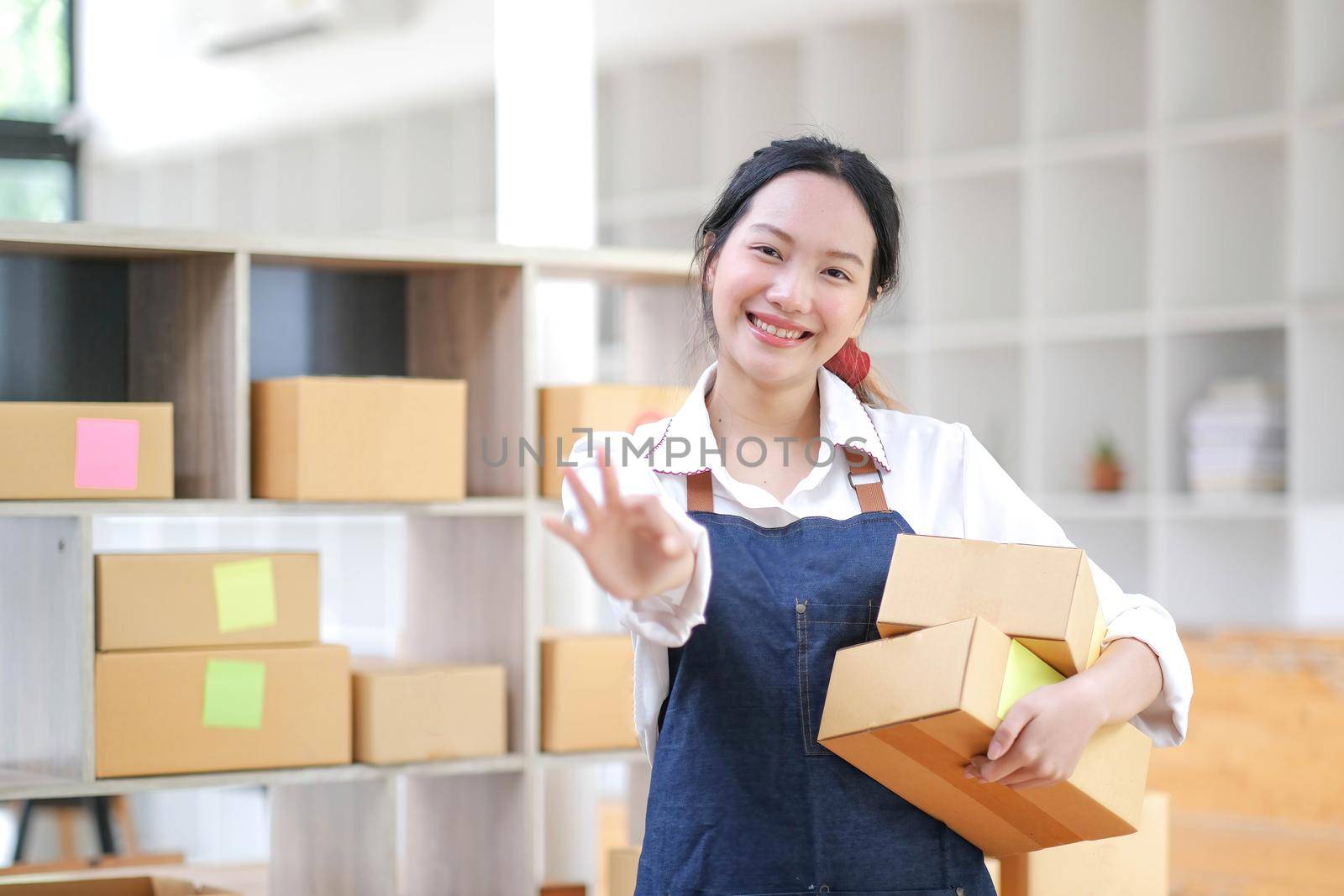 Portrait of Asian young woman working with a box at home the workplace.start-up small business owner, small business entrepreneur SME or freelance business online and delivery concept..