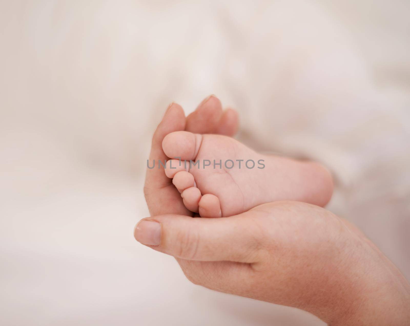Gentle mothers touch. Cropped view of a young mother rubbing the foot of her infant. by YuriArcurs