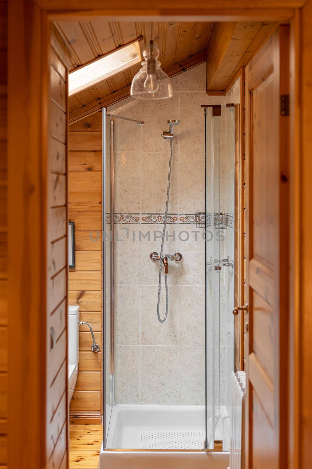 Interior of bathroom in country style. Shower cabin with wooden walls.