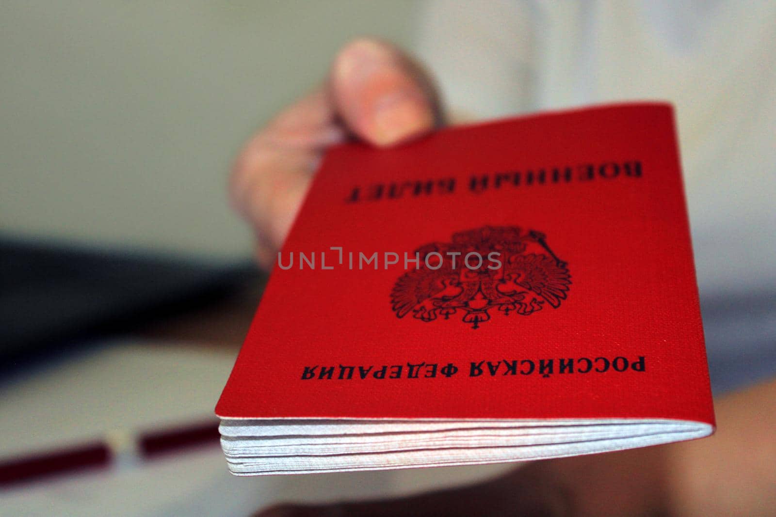 The girl holds out a military ID issued by the Russian Federation. Close-up. Blurred background. The concept of mobilization by IronG96