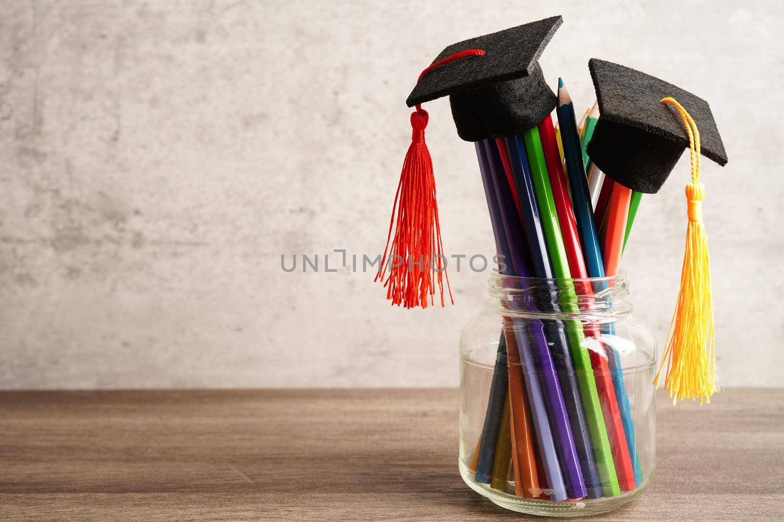 Graduation hat with colorful pencils on book with copy space, learning university education concept.