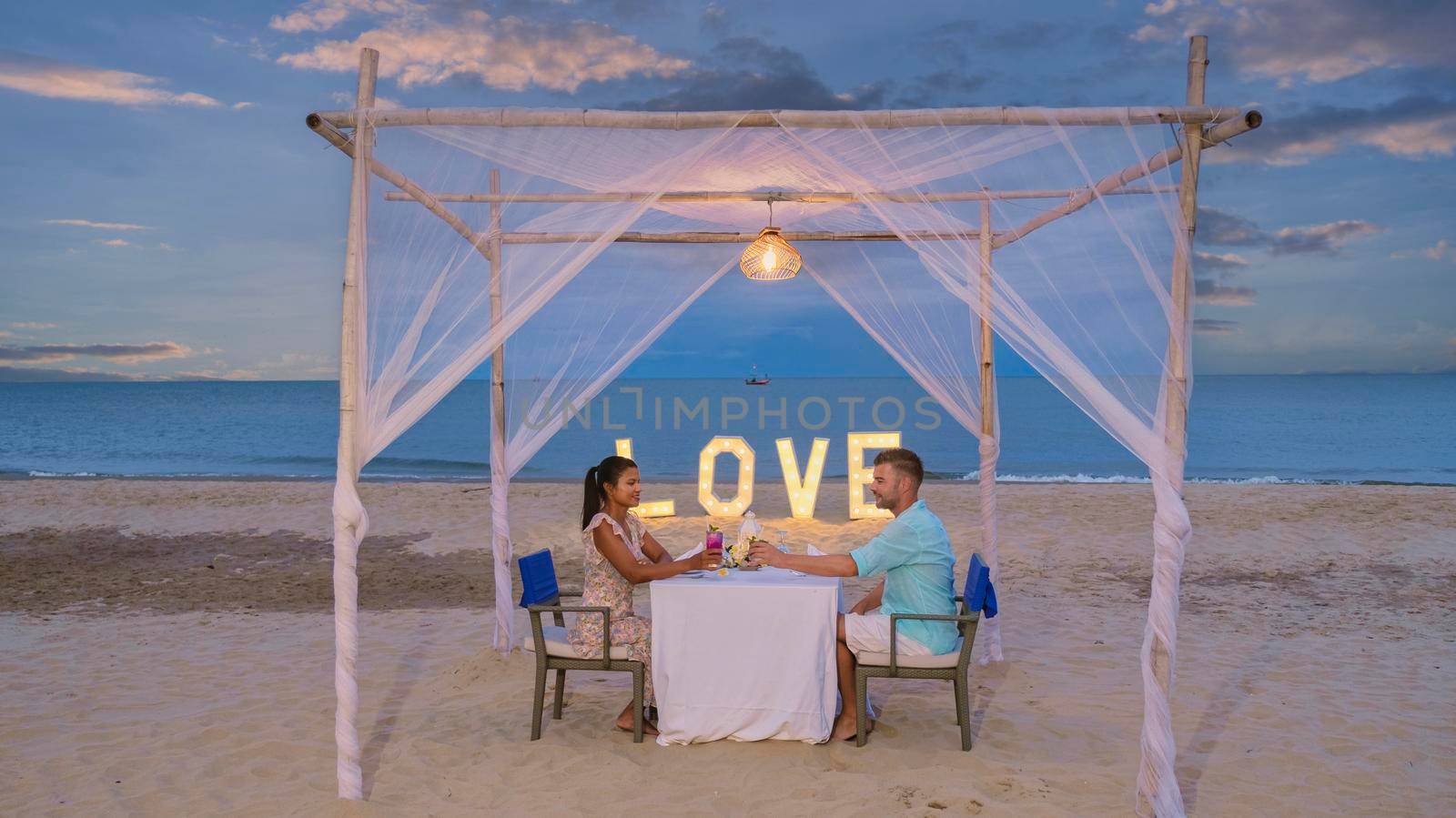 Romantic dinner on the beach of Huahin Thailand, dinner by candlelight in Hua Hin, Valentine's concept. Couple of men and women having a romantic dinner on the beach in Thailand